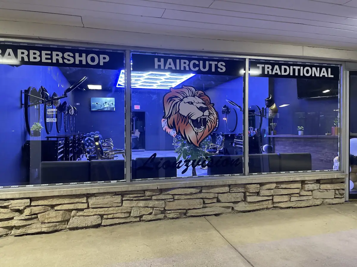 Lionzvision storefront at night, lion logo glowing in the window